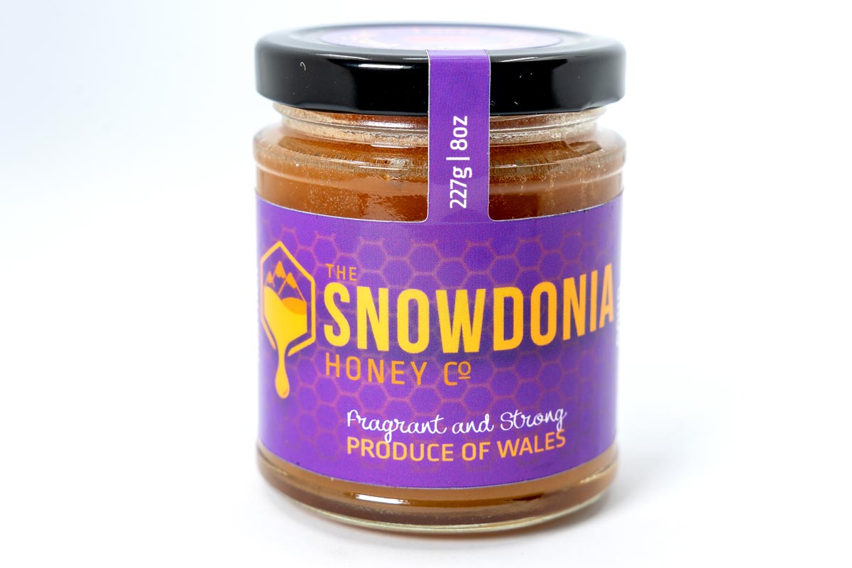 Honey jar label for The Snowdonia Honey Co with bold purple and yellow design, showing 227g produce of Wales.