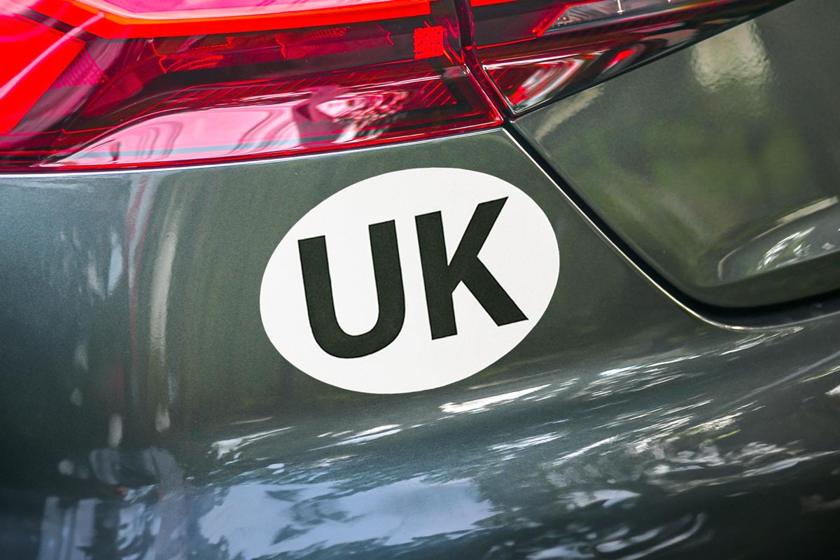 UK Vehicle sticker with bold black lettering on a white oval background, designed for clear identification when driving